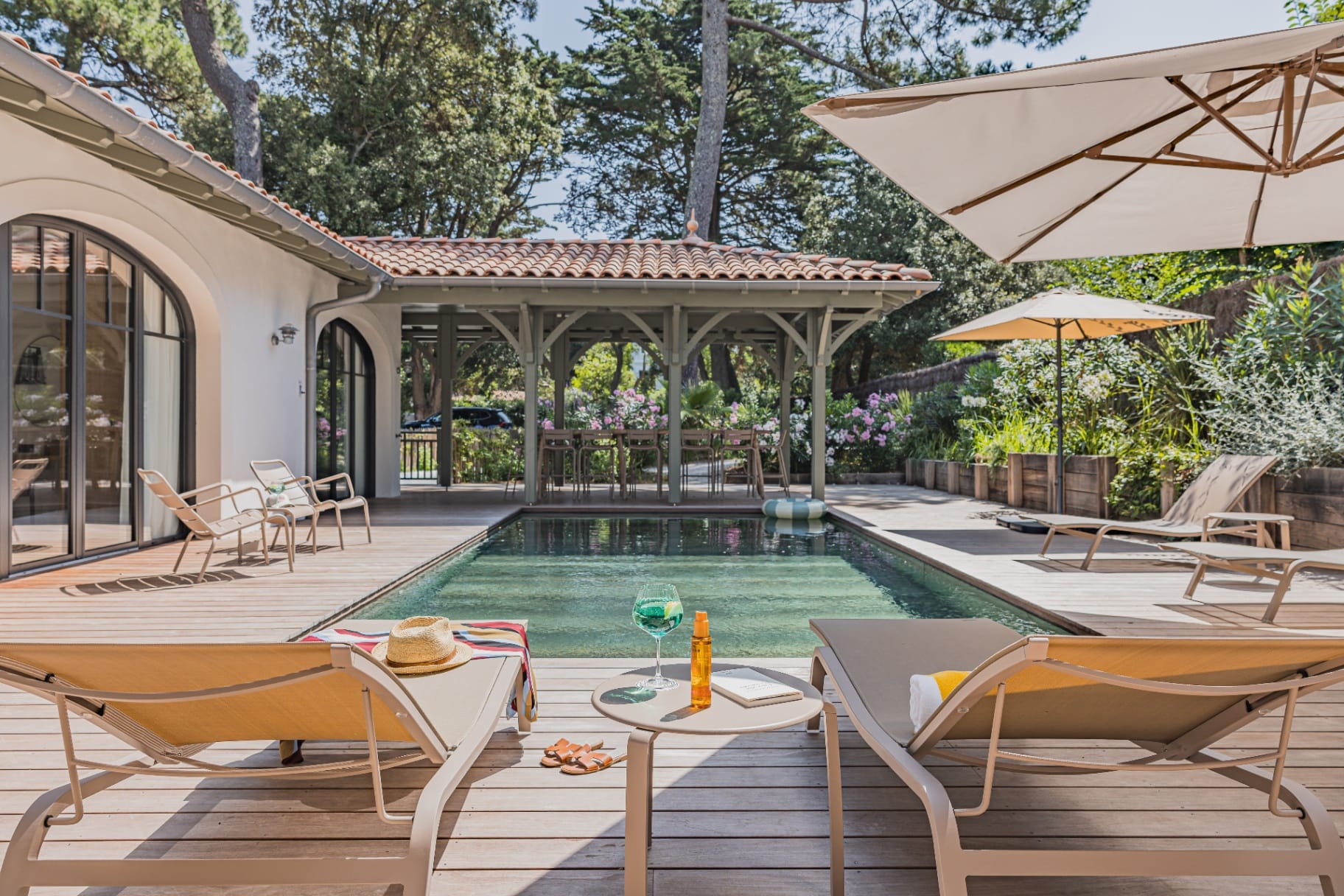 Terrasse en bois et piscine chauffée de la Villa La Perla face à l'océan